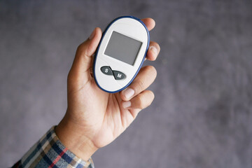 man's hand measuring blood sugar level 