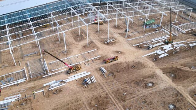 Construction cranes and workers are building large warehouse hyperlapse