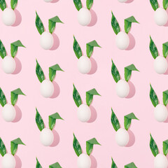 Easter abstract pattern made of white eggs with fresh green leaves as bunny ears on bright pink background. Minimal spring holiday concept. Creative surreal layout with sunshine shadow.