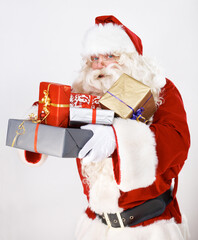 Bringing you some Christmas magic. Santa Claus holding a pile of wrapped christmas gifts - portrait.