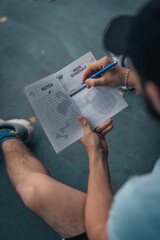Naklejka premium Person writing down in a notebook during traning session.