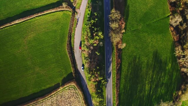 Aerial top down drone shot above the winding welsh valley road In brecon near the beacons, Wales. sunny afternoon winter weather. Car driving through the curve 4K. Flying straight up
