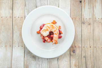 View from above of a dish with a big shrimp on top.