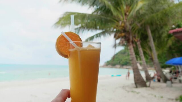 Orange juce on the beach sea coast shore or orange fresh juice summer surf wave background refreshing drink relax positive mood vacation
