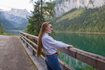 Beautiful young girl walking by the lake in the Alps
