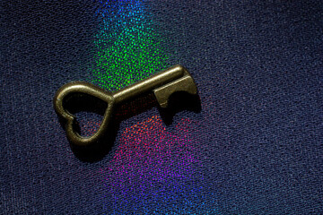 Vintage key. .Antique key. Retro key with a heart shape on  on colorful fabric