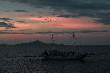 Naklejka na ściany i meble fishing boat at sunset over the sea 