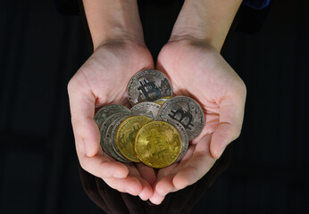 Bitcoin coins in the hand of a  women