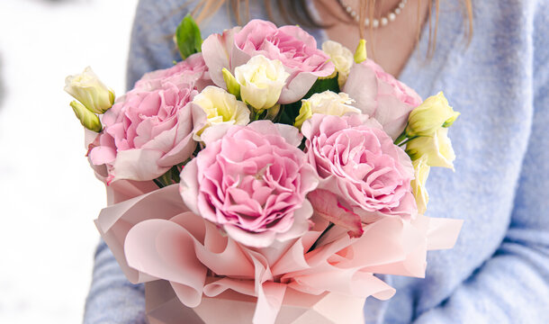 Close-up of a bouquet of roses in female hands.