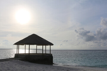 Maldives, the deserted beach with water cafe. Sunset in the ocean