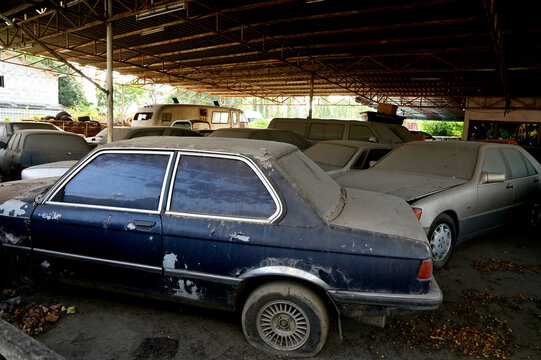BANGKOK, THAILAND - March 05, 2022 : Old cars parked for a long time with dust in the garage (old car cemetery) in Thailand.