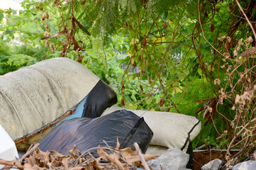Closeup of The old sofa is left with garbage. In the grassy forest along the way.