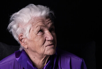 Portrait of serious senior woman against black background