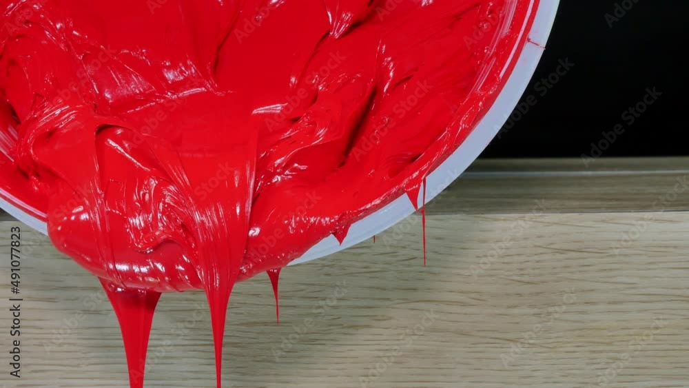 Poster red ink slowly dripping from white bucket..high quality video 4k. filming in the studio..color and p