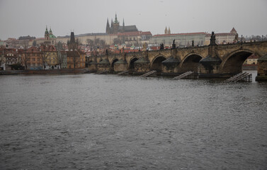 Fototapeta premium winter rainy day in Prague - view of Vltava river, Charles bridge and Prague castle