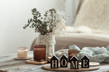Close up decorative word home on blurred background with candles.