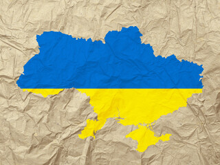 The outline of the state of Ukraine in the colors of the national flag on crumpled paper texture. Digital art. 