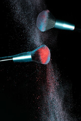 Make up brushes colliding together and exploding with powder