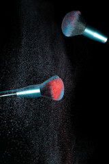 Make up brushes colliding together and exploding with powder