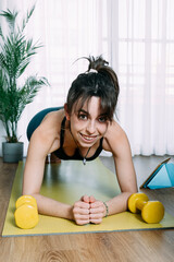 Young woman doing push-ups on yoga mat at home. Fitness girl doing pushups on exercise mat.