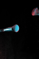 Make up brushes colliding together and exploding with powder