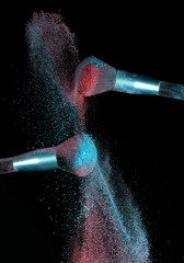 Make up brushes colliding together and exploding with powder