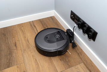 A modern robotic vacuum cleaner that charges in a docking station, an autonomous cleaning robot.