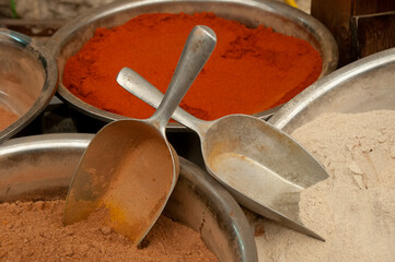 Paprika, cinnamon, and powdered ginger spice in metals bowls in the outdoor market in Jerusalem.