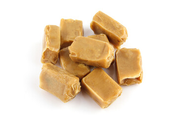 Pile of brown caramels isolated
on white background. Milky toffee treat