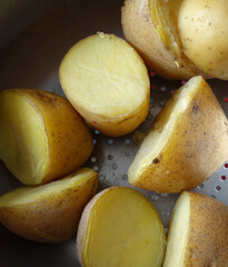 boiled whole potatoes in a bowl, boiled potatoes in water, boiled potatoes with close-up shot,