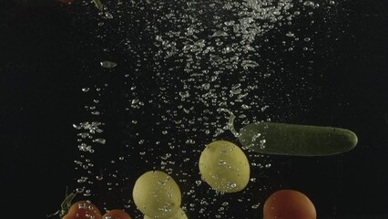 Tomato, cucumber, lemon, green pepper and red pepper falling into water in slow motion. - Powered by Adobe