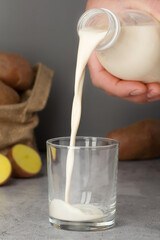 Close-up view of potato milk being poured, highlighting its texture and natural ingredients.