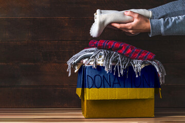 Box with donation clothes for ukrainian refugees suffering from war. Charity and Helping poor and...