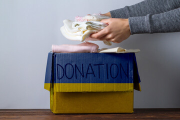 Box with donation clothes for ukrainian refugees suffering from war. Charity and Helping poor and...