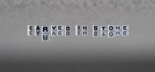 carved in stone word or concept represented by black and white letter cubes on a grey horizon...