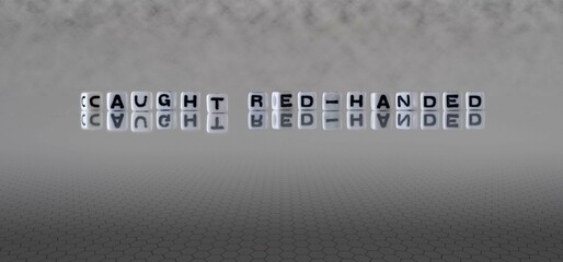 caught red handed word or concept represented by black and white letter cubes on a grey horizon...