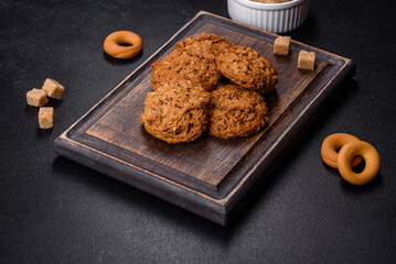 Tasty fresh oat cookies on a dark concrete background