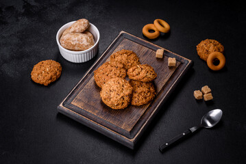 Tasty fresh oat cookies on a dark concrete background