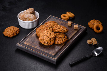 Tasty fresh oat cookies on a dark concrete background