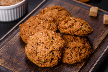 Tasty fresh oat cookies on a dark concrete background