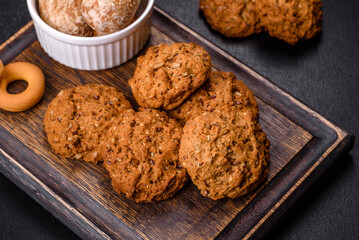 Tasty fresh oat cookies on a dark concrete background