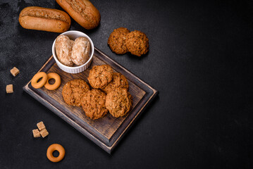 Tasty fresh oat cookies on a dark concrete background