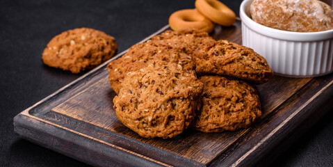 Tasty fresh oat cookies on a dark concrete background