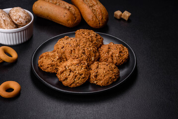 Tasty fresh oat cookies on a dark concrete background