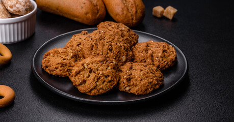 Tasty fresh oat cookies on a dark concrete background