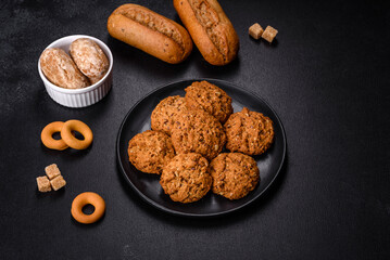 Tasty fresh oat cookies on a dark concrete background