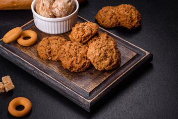 Tasty fresh oat cookies on a dark concrete background