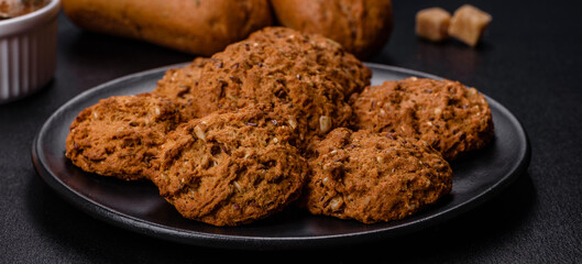 Tasty fresh oat cookies on a dark concrete background