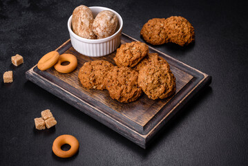 Tasty fresh oat cookies on a dark concrete background