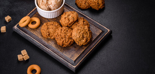 Tasty fresh oat cookies on a dark concrete background